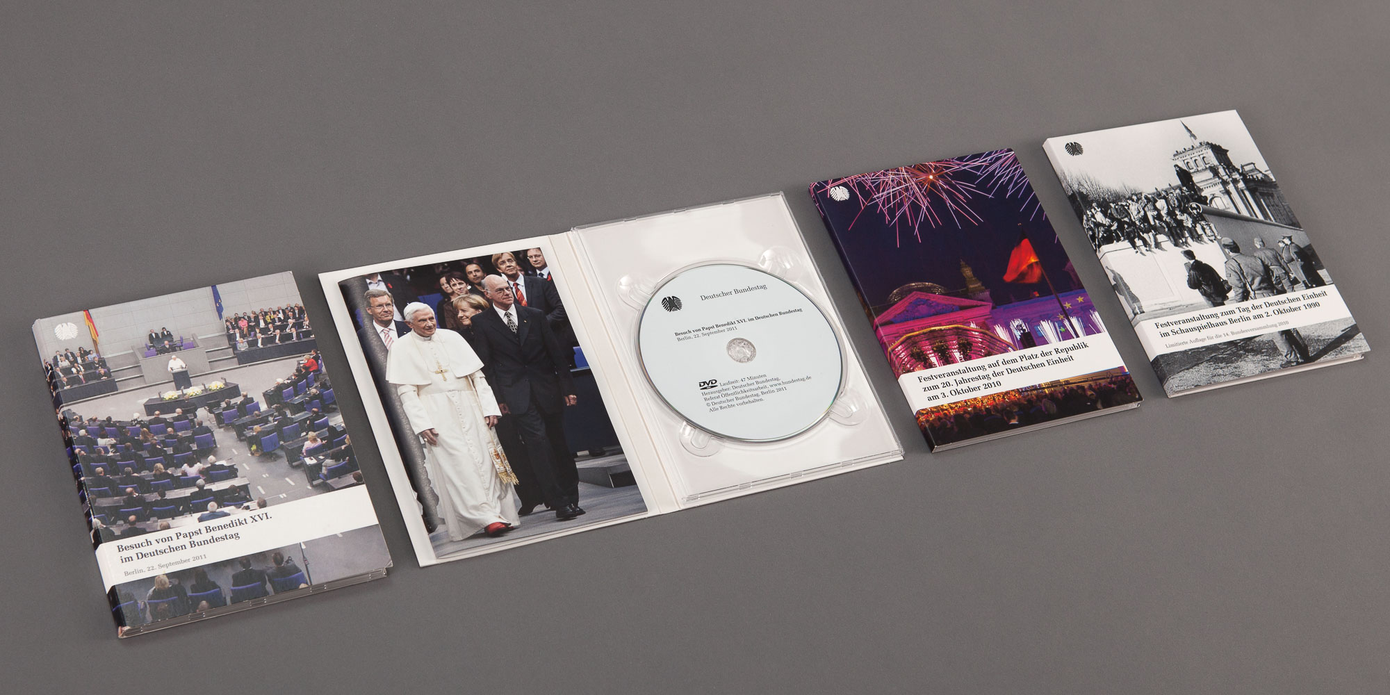 Das Foto zeigt nebeneinander gelegt aufgeschlagene und geschlossene Beispiele von DVDs mit Booklets.